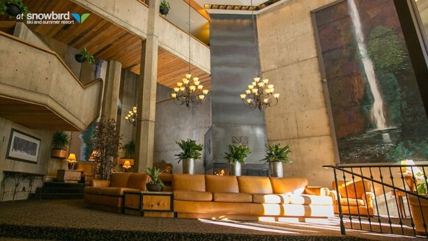 A spacious lobby with a high ceiling, a central seating area with a sofa and armchairs, and a staircase leading to an upper level. - Snowbird's PREMIER Ski-in Ski-out Suite @ Iron Blosam Lodge (Snowbird)