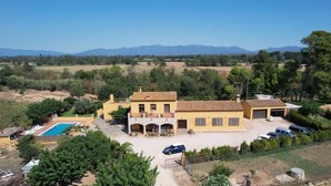 Une grande villa dotée d’une piscine, de plusieurs garages et d’un vaste espace extérieur.