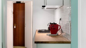 Una cocina con encimera de madera, una cafetera roja y un salpicadero de azulejos.