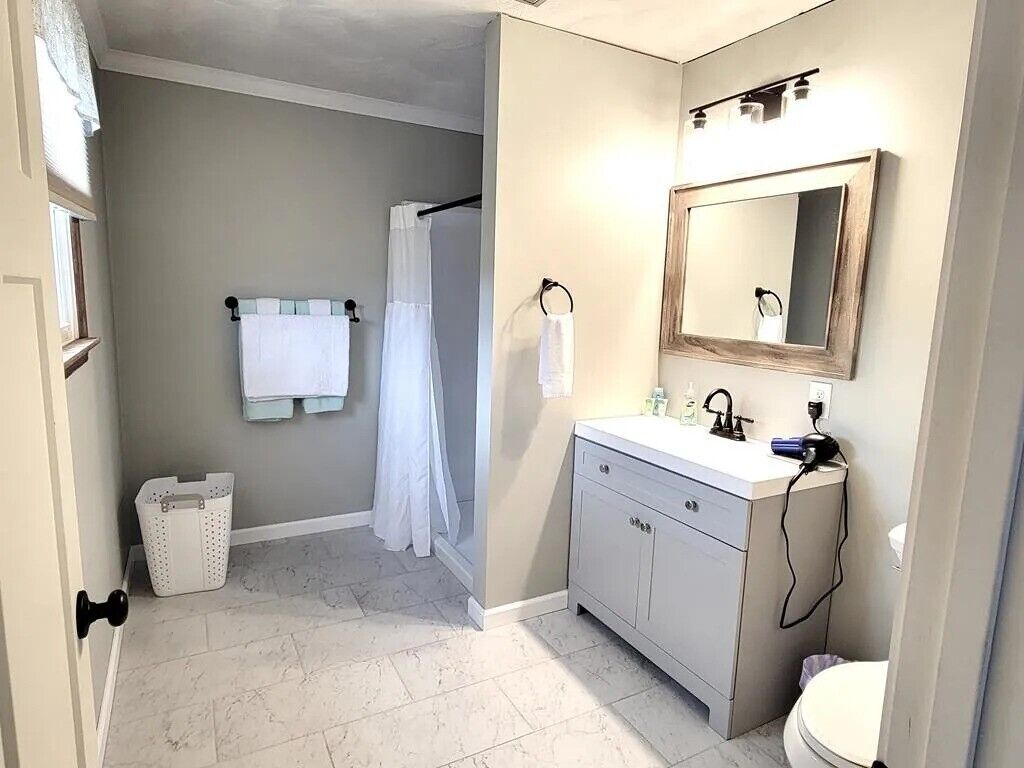 A bathroom with a white sink, a mirror, and a shower curtain.