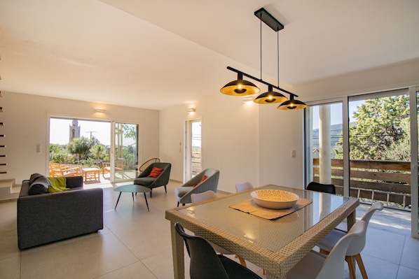 Una sala de estar moderna con una mesa de comedor, sillas y un sofá.