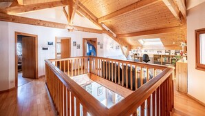 A spacious loft with wooden beams, a wooden railing, and skylights. - Chalet 'Pierre Et Bois' with Mountain View, Private Terrace and Wi-Fi (AIGUEBLANCHE)
