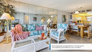 Una sala de estar con sofá, sillones, una mesa de centro y un comedor con sillas y una mesa.