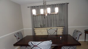 A dining room with a rectangular table, four patterned chairs, a cream-colored cabinet, and a chandelier. - CLOSE TO FT JACKSON, WILLIAMS-BRICE STADIUM, VA HOSP, FAMILY FRIENDLY. SLEEPS 10 (Columbia)