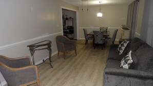 A living room with a gray sofa, two armchairs, a dining table with four chairs, a small side table, and a ceiling fan. - CLOSE TO FT JACKSON, WILLIAMS-BRICE STADIUM, VA HOSP, FAMILY FRIENDLY. SLEEPS 10 (Columbia)