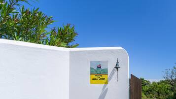 Un mur blanc sur lequel est apposée une plaque portant l’inscription « Monte do Cerro Verde ».