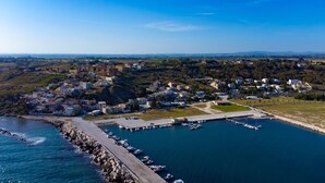 Un poble costaner amb un port esportiu, edificis i un paisatge amb muntanyes.