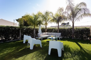 A well-maintained outdoor seating area with a white sofa, two white chairs, and a coffee table. - Holiday Home 'Torre Del Mare' with Private Pool, Private Terrace and Wi-Fi (Menfi)