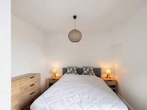 A bedroom with a bed, two bedside tables with lamps, a wooden dresser, and a hanging light fixture. - Comfortable Mountain Stay in Formiguères: 4Bedrooms, 9Min from the Ski Resort with Private Terrace ! (Formiguères)
