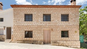 A stone building with a tiled roof, a central door, and three windows. - Apartment 'Villacalar Ill' with Mountain View, Private Terrace and Wi-Fi (Calar de la Santa)