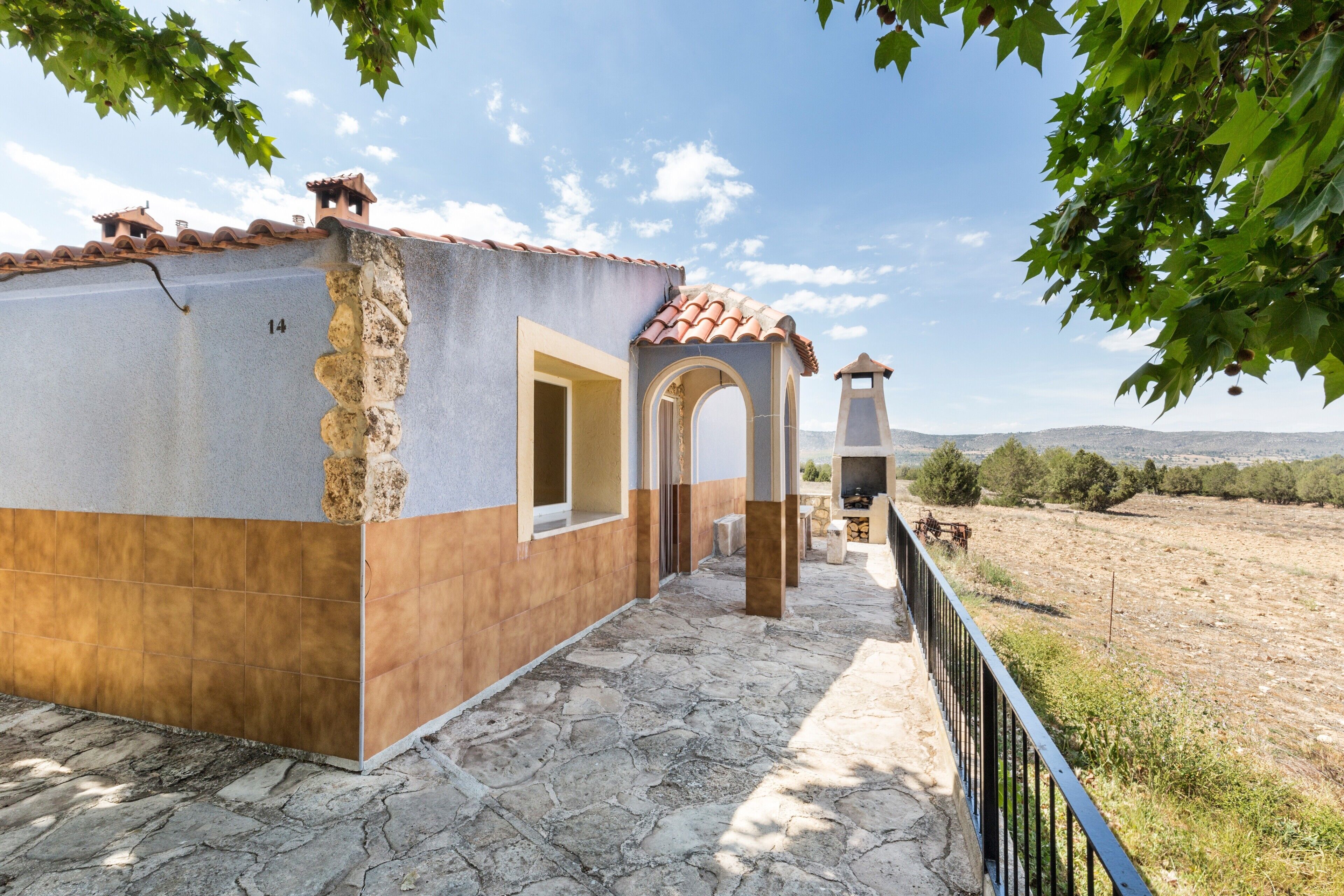 Un bâtiment doté d’une façade en pierre, d’un toit en tuiles et offrant une vue sur la campagne.