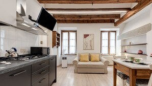 Una cocina moderna con estufa integrada, microondas y un televisor de pantalla plana montado en la pared.