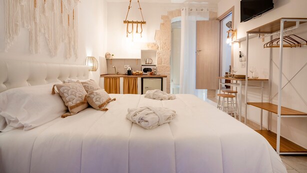 A bedroom with a large bed, a desk, and a television. - Apartment 'Perla' with Private Terrace and Optional SPA in Castellana Grotte (Castellana Grotte)