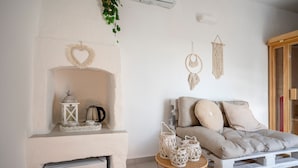 A cozy living room with a fireplace, a sofa, and decorative wall hangings. - Apartment 'Perla' with Private Terrace and Optional SPA in Castellana Grotte (Castellana Grotte)