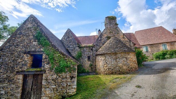 A stone building with a triangular roof, a small window, and a door. - Gîte Déodatus in Cladech – House with Garden, Saltwater Pool, and Air Conditioning (Cladech)
