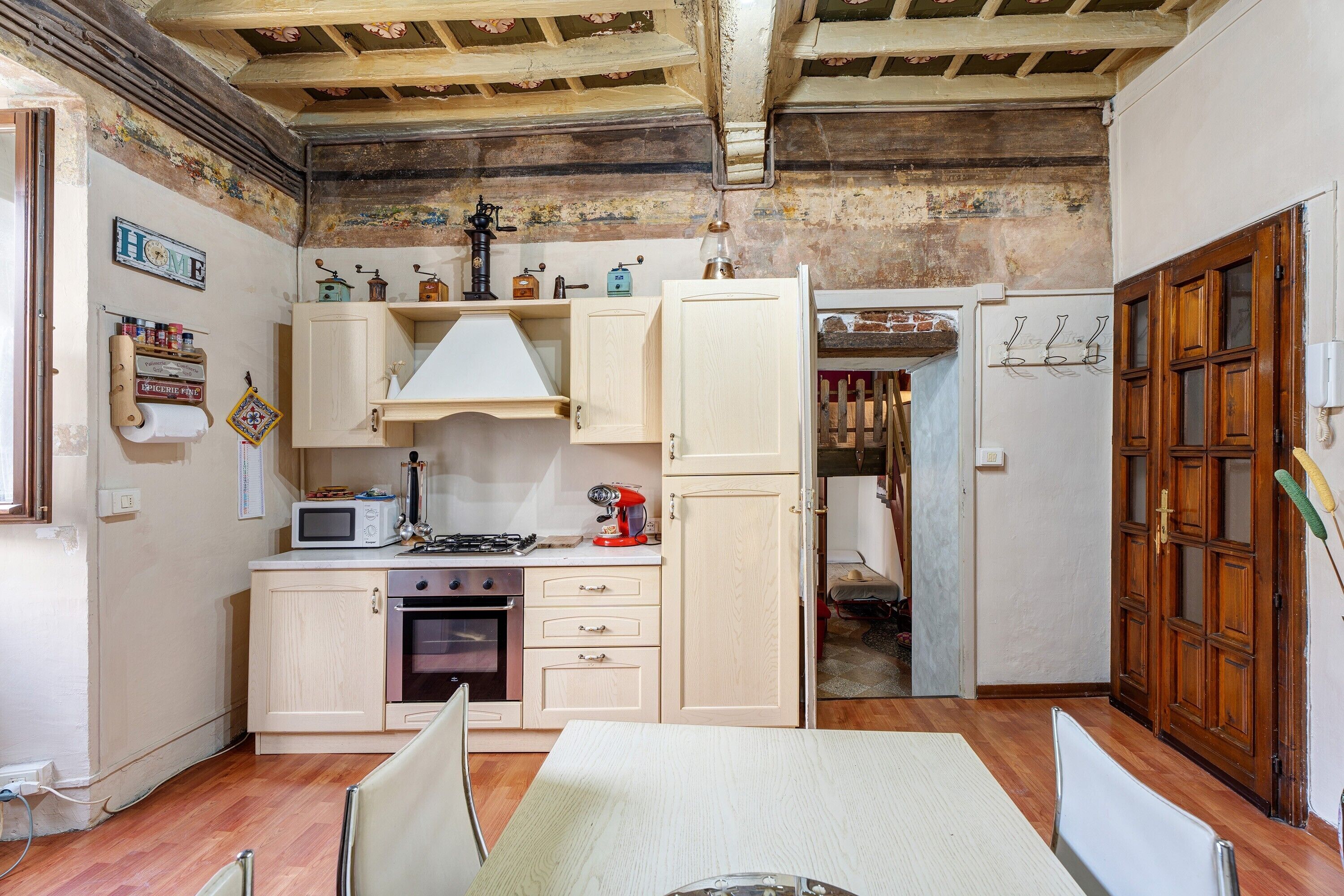 A compact kitchen with wooden cabinets, a microwave, a stove, and a refrigerator.