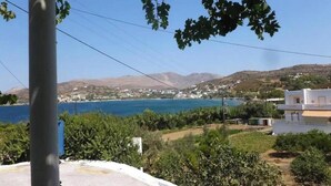 A coastal landscape with a clear view of the sea, a building with a white facade, and a hill in the background. - Apartment 'Akrogiali House Drimonas' with Sea View, Wi-Fi and Air Conditioning (Leros)