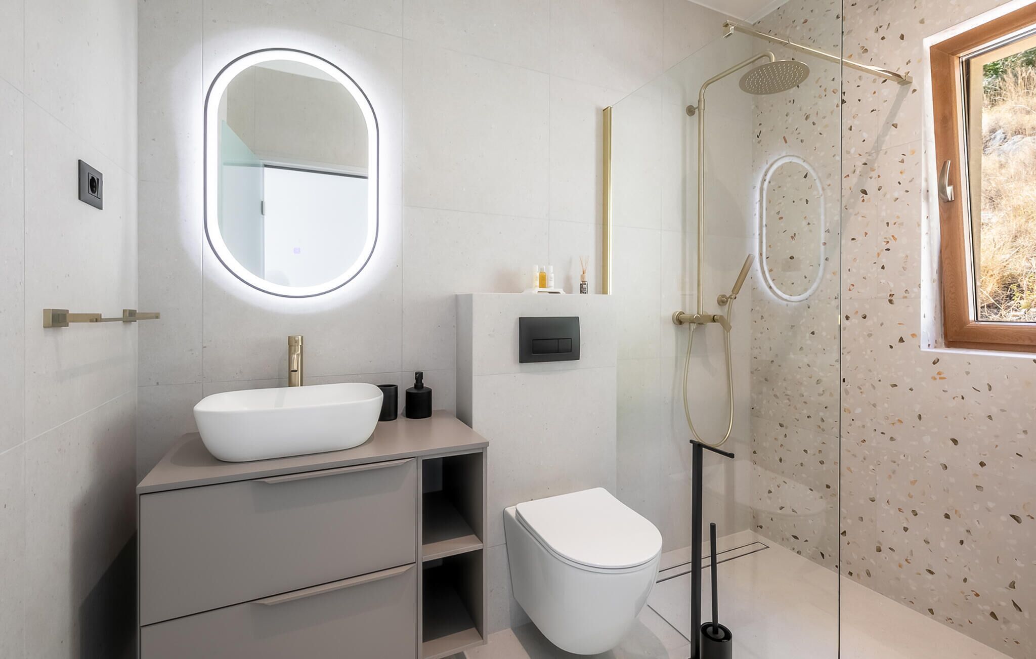 A modern bathroom with a white sink, a mirror, a toilet, and a shower area.