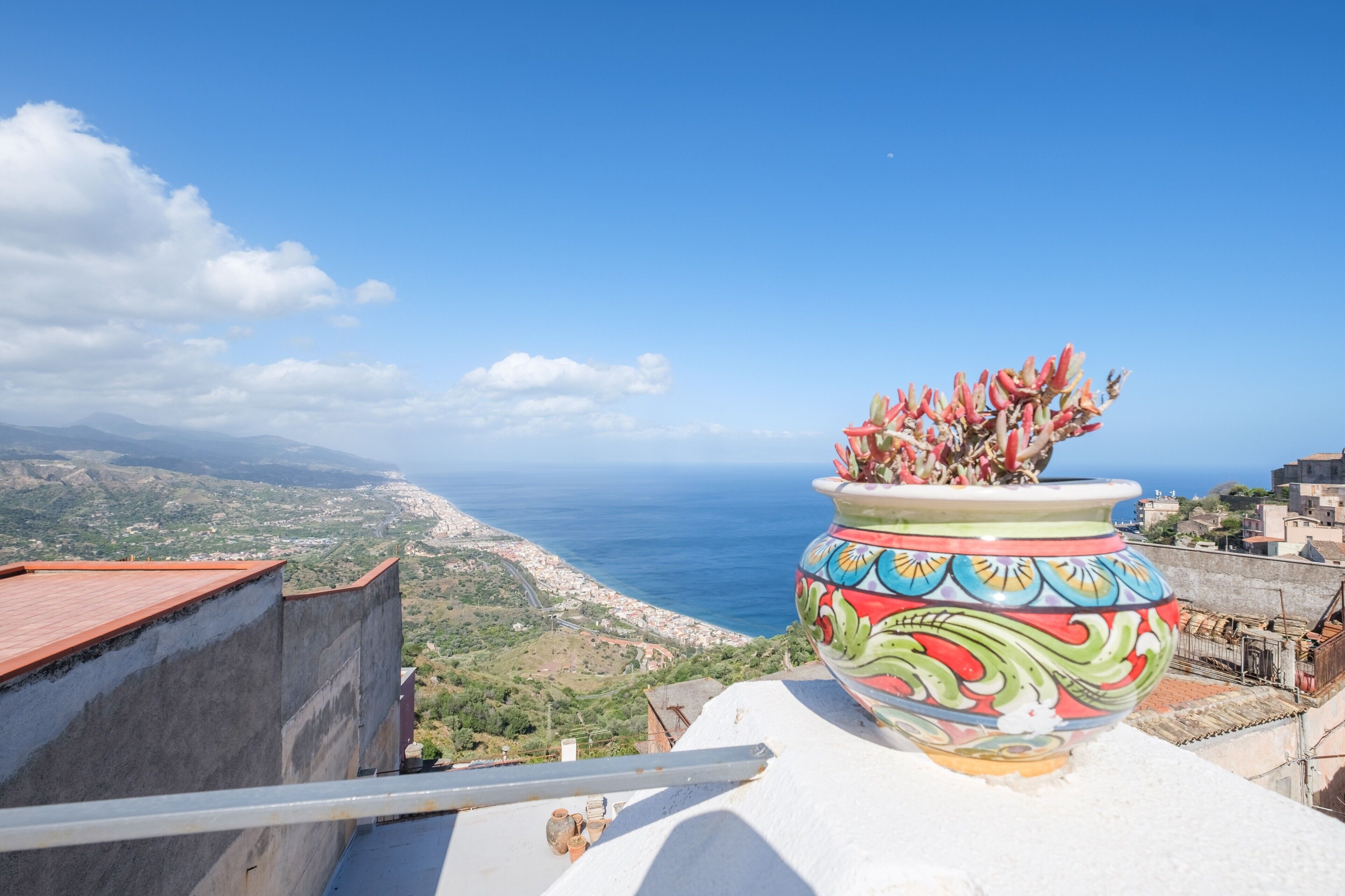 Vista costera con una maceta decorativa en un balc ón.
