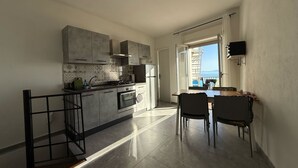 A modern kitchen with a view of the sea, a dining area with chairs, and a staircase. - Holiday Home 'Casa Mark' with Sea View, Wi-Fi and Air Conditioning (Forza d'Agrò)