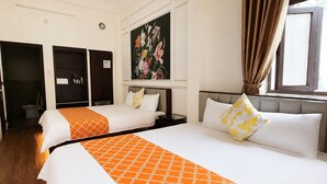 A hotel room with two beds, a painting on the wall, and a window with curtains. - Collection O Queen Hotel Central Hue (Hue)