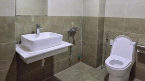 A bathroom with a white sink, a toilet, and a shower area. - Collection O Queen Hotel Central Hue (Hue)