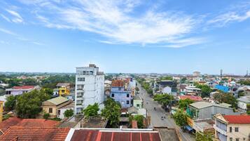 A cityscape with a variety of buildings, including a prominent white tower and colorful residential structures.
