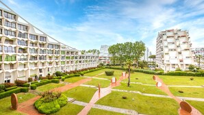 Un hotel moderno con patio interior, varios pisos y una combinación de balcones y ventanas.