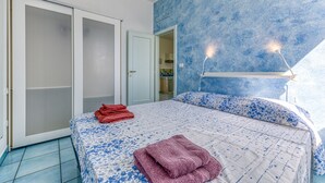 Une chambre à coucher avec un lit, une porte et un mur orné d’un motif texturé.