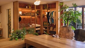 A wooden interior with shelves, a large potted plant, and a clothing rack. - Best Bet Motor Lodge  (Reno)