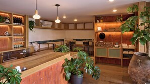 A restaurant with wooden furniture, pendant lighting, and potted plants. - Best Bet Motor Lodge  (Reno)