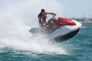 Un jet ski en movimiento, levantando una gran cantidad de agua.