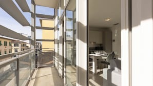 Un apartamento moderno con balcón, ventanas amplias y una zona de cocina.