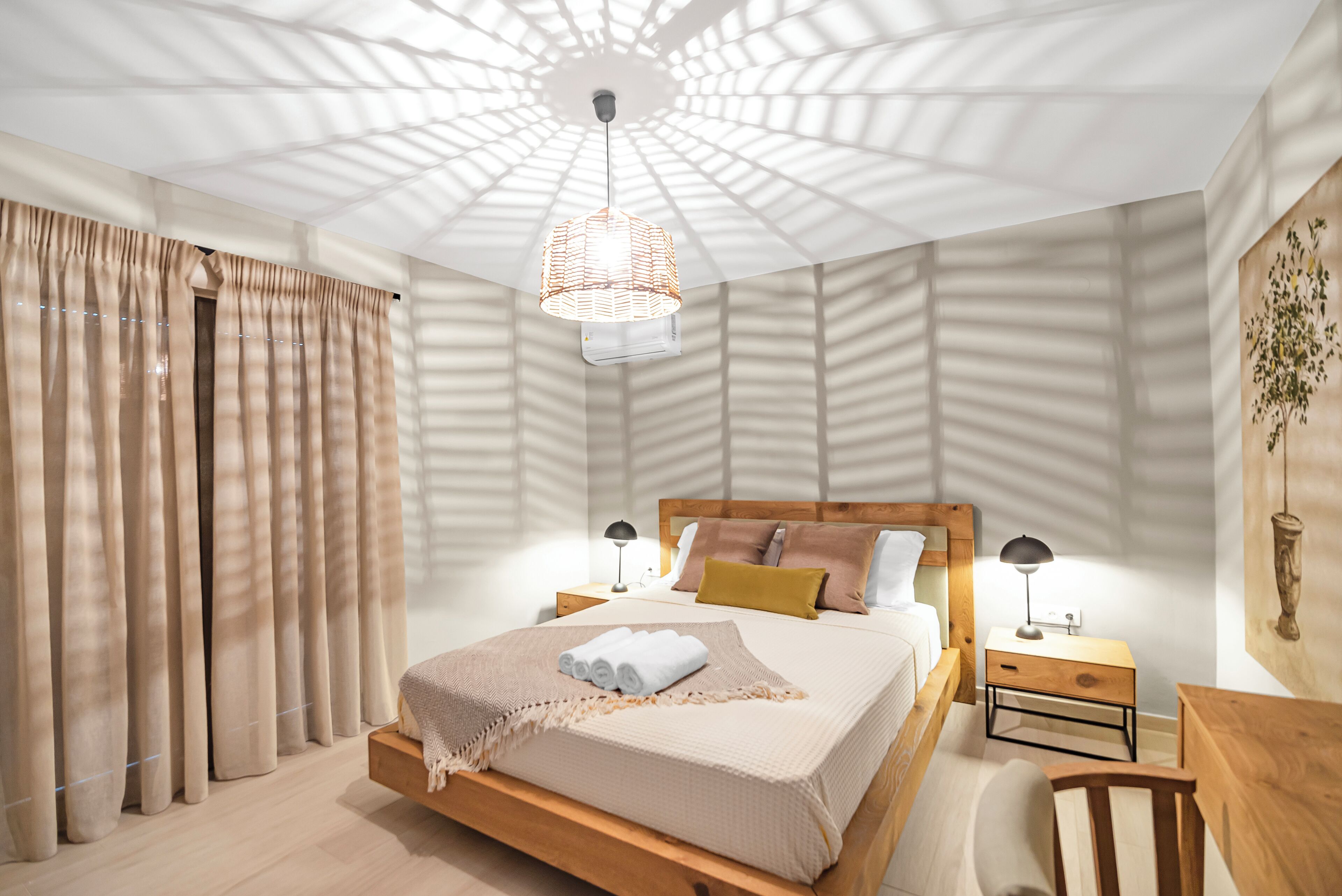 A modern bedroom with a large bed, wooden headboard, and a ceiling light fixture.