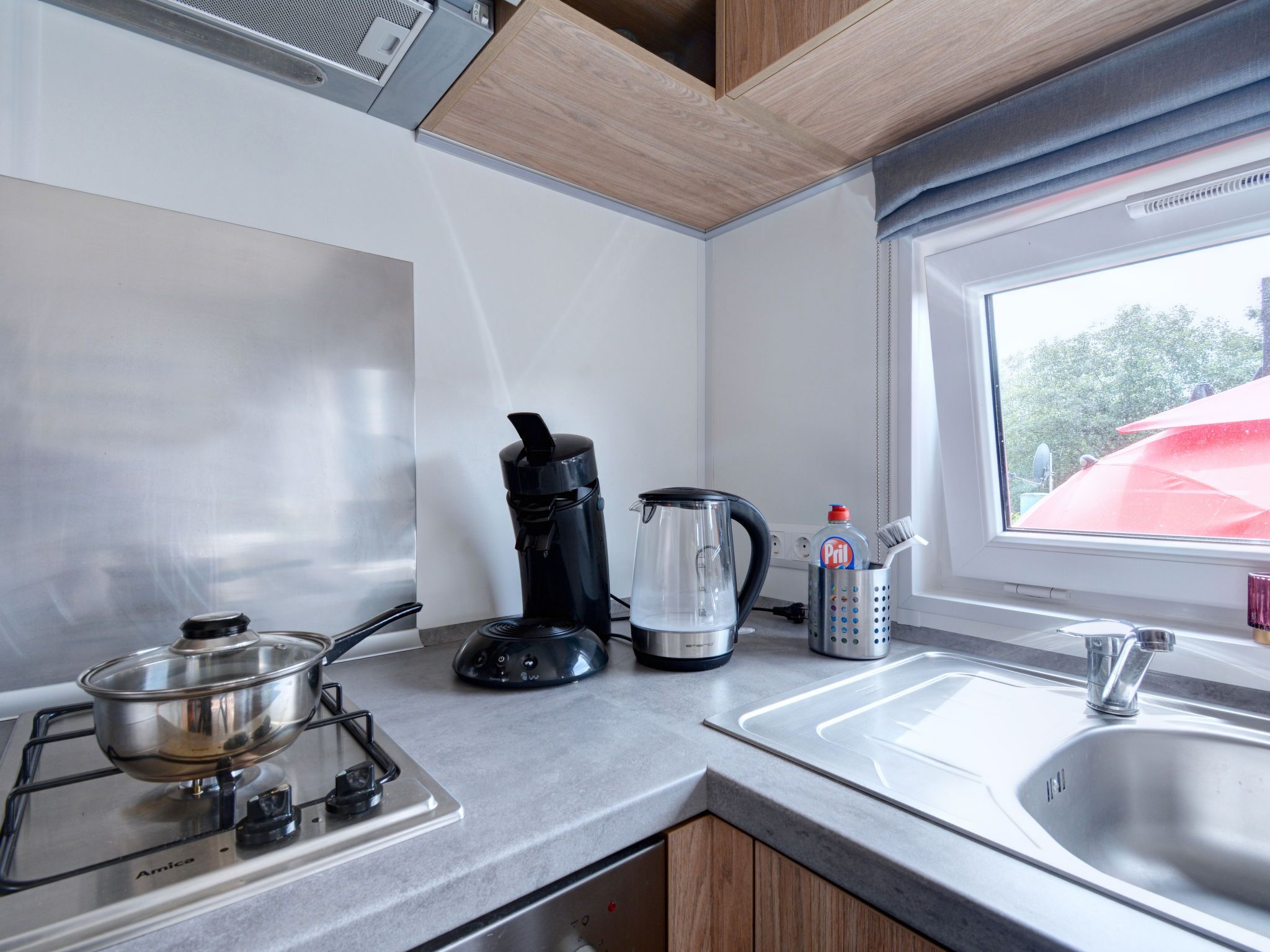 Eine moderne Küche mit Gasherd, Kaffeemaschine, Wasserkocher und Spüle.