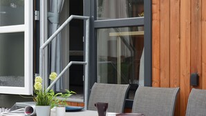 Un espace extérieur aménagé pour les repas, avec une table, des chaises et une plante en pot.
