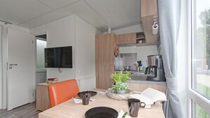 Une cuisine moderne avec des meubles en bois, un four encastré et une machine à café.