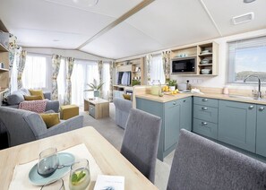 A compact living space with a dining area, kitchenette, and seating area.