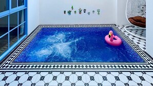 A small indoor pool with a pink inflatable ring, surrounded by a tiled floor and walls with a geometric pattern. - Serena Villa, Da Nang city, Vietnam, 3 bedrooms, near the beach (Đà Nẵng)