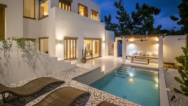 A modern house with a swimming pool, outdoor seating, and a well-lit patio area. - Villa Oasi 1 by Alfred in Bali (Pecatu)
