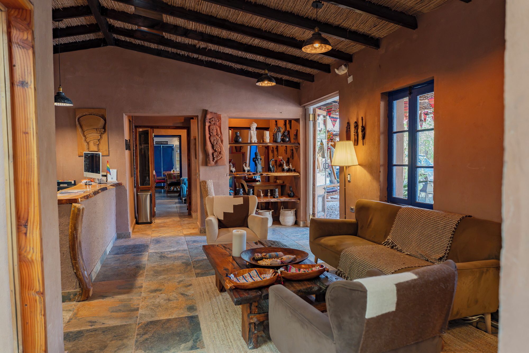 Un interior acogedor con suelo de piedra, muebles de madera y vista por una ventana.