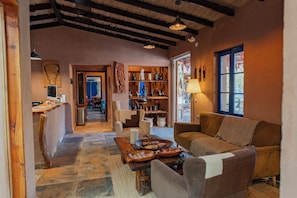 A cozy interior with a stone floor, wooden furniture, and a view through a window.
