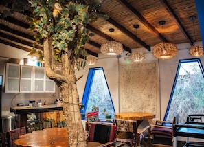 A cozy interior with a large tree, wooden ceiling, and a map of Patagonia.