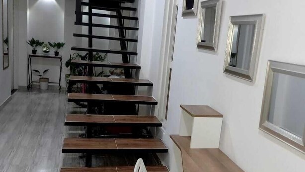 Un interior moderno con una escalera, un escritorio y una silla.