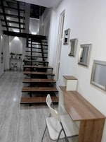 Un interior moderno con una escalera, un escritorio y una silla.