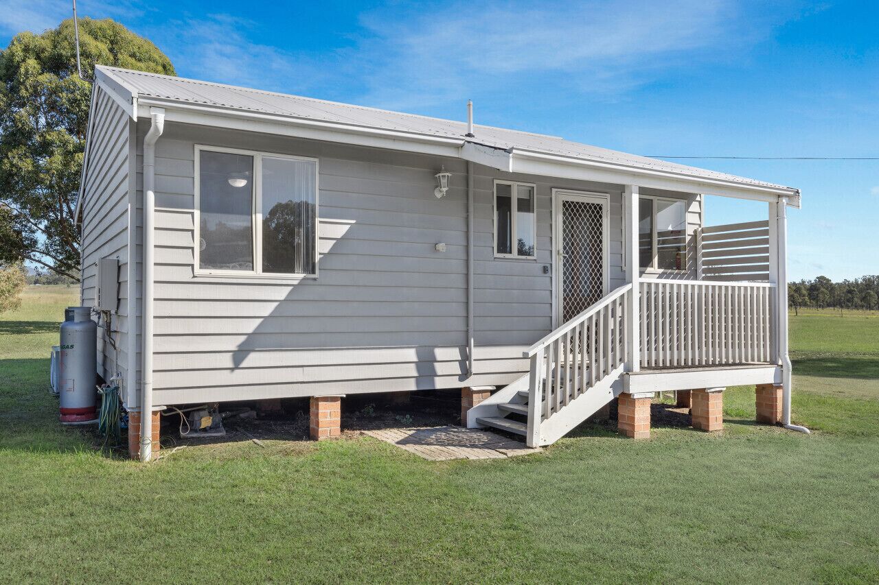 Une maison mobile de plain-pied avec un porche à l’avant et une petite terrasse.