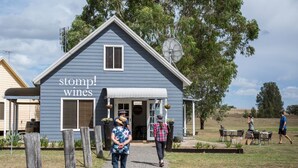 Un edificio rústico con un letrero que dice "stomp! wines" y un área de estar al aire libre techada.