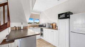 Køleskab, mikrobølgeovn, kogeplade, køkkentøj/tallerkener/redskaber