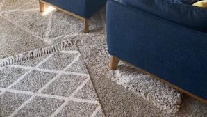 Un salon avec un canapé bleu, un pouf et une cheminée.