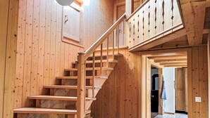 Eine Holztreppe mit Handlauf, die zu einer oberen Ebene führt.